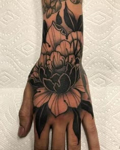 a person's hand with tattoos on it and flowers in the middle of their palm