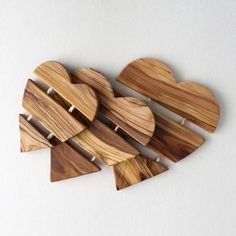 four wooden heart shaped magnets sitting on top of each other