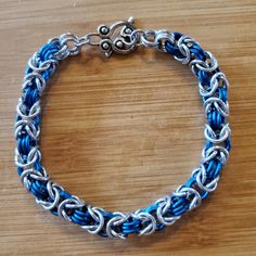 Silver And Pacific Blue Hand Crafted Chain Mail Bracelet Measuring 8.5" Long And 1/4" Wide. Toggle Clasp Closure. New, Never Worn. Great Unisex Accessory For Ren Faires And Festivals! Adjustable Blue Jubilee Chain Bracelet, Blue Metal Bracelet With Lobster Clasp, Adjustable Blue Metal Chain Bracelet, Blue Chain Link Metal Jewelry, Adjustable Nickel-free Blue Chain Bracelet, Adjustable Blue Nickel-free Chain Bracelet, Adjustable Blue Chain Bracelet, Chainmail Bracelet, Blue Hand