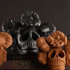 there are three skulls and two flowers on the table