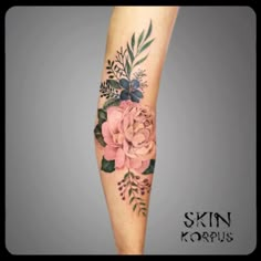 a woman's leg with flowers and leaves tattooed on her arm, in the shape of a flower