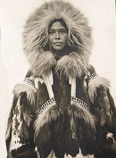 an old black and white photo of a person wearing a fur coat with hood on