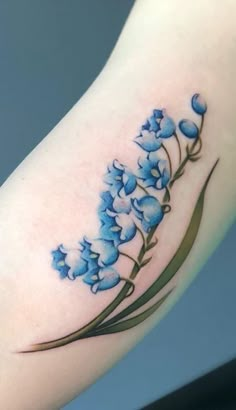 a blue flower tattoo on the arm