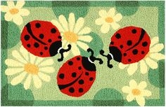 two ladybugs on a green rug with daisies