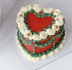 a heart - shaped cake decorated with green and red icing