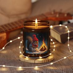 a candle that is sitting on top of a table next to some string lights and a guitar