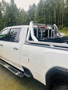 a white truck parked in front of some trees