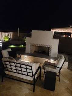 two chairs sitting next to each other in front of a fire place on top of a roof