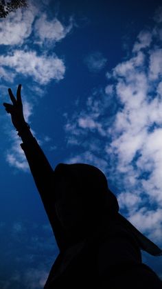 a person reaching up into the sky with their hands