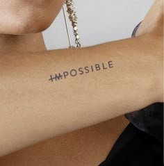 a woman's arm with the word impossible written on it