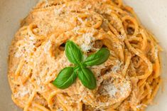 spaghetti with basil and parmesan cheese in a white bowl