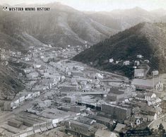 an old black and white photo of a town in the mountains