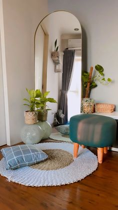 a living room filled with furniture and potted plants on top of a wooden floor