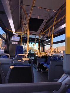 the inside of a bus with blue seats and yellow railings on it's sides