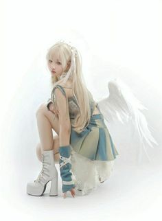 a woman sitting on top of a pair of white shoes next to an angel wing