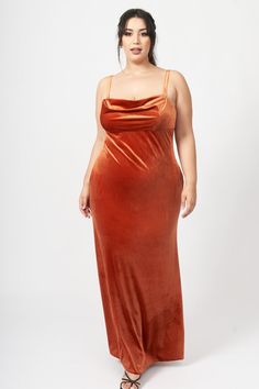 a woman in an orange dress poses for the camera with her hands on her hips