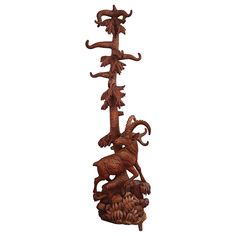 a wooden sculpture with an animal on it's back and three branches in the middle