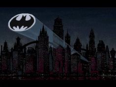 the batman logo is shown in front of a cityscape with skyscrapers at night