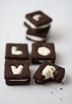 chocolate cookies with white icing are stacked on top of each other in the shape of hearts