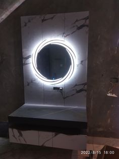 a bathroom with a round mirror on the wall and marble counter top in front of it