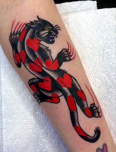 a black and red cat with hearts on it's leg