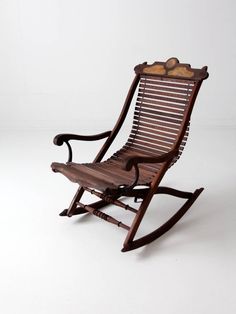 a wooden rocking chair sitting on top of a white floor