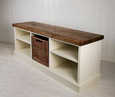 a white shelf with wicker baskets on it and a wooden top that is open