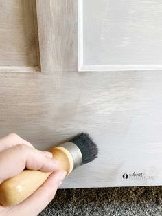 someone using a brush to paint a door