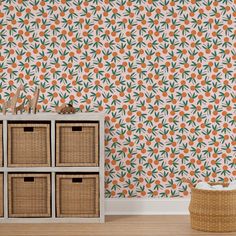 an orange and green floral wallpaper in a living room with wicker baskets on the floor