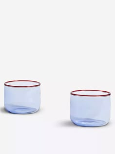 two empty glass bowls with red rims