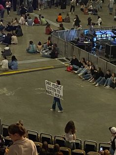 a person holding a sign in an arena