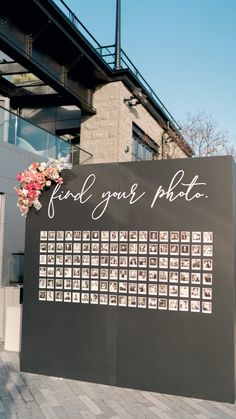 a large black sign with pictures on it that says find your photo in front of a building