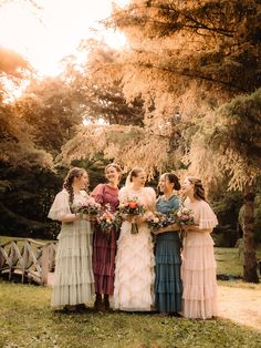 a group of women standing next to each other on top of a lush green field