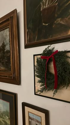 the wall is decorated with pictures and wreaths