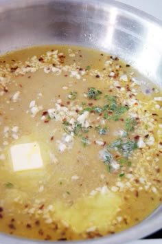 a metal bowl filled with soup on top of a stove