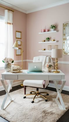 a white desk with a laptop on top of it in front of a pink wall