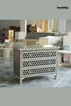 a black and white cabinet sitting on top of a tiled floor