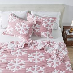 a bed with pink and white snowflakes on it