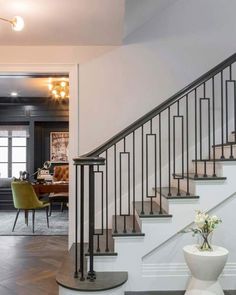 a living room filled with furniture and a stair case next to a dining room table