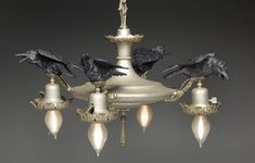 a chandelier with five black birds on it