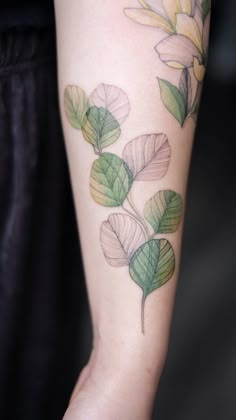 a close up of a person's arm with leaves on it