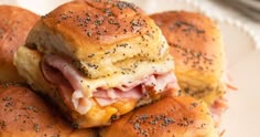 ham and cheese sliders stacked on top of each other with poppy seed sprinkles