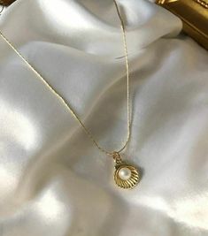 Embrace the elegance of the ocean with this Gold-Plated Pearl Shell Necklace. This elegant piece features a beautifully crafted shell necklace that houses a lustrous pearl. Perfect for beach lovers and those who appreciate the subtle beauty of the sea, this necklace is perfect for both everyday and special occasion wear. The gold-plated chain adds a touch of elegance, making it a timeless addition to your jewelry collection or a thoughtful gift for someone special. Details: * Color: Gold * Material: Gold-plated alloy, imitation pearl * Pendant Size: Approx. 1 cm x 1 cm (shell and pearl) * Chain Length: 45 cm (18 inches) with adjustable extension * Closure: Parrot clasp * Care Instructions: Avoid contact with water, perfume and other chemicals. Store in a dry place when necklace is not in u Elegant Cheap Shell Necklaces, Shell Necklace With Pearl Pendant, Elegant Pearl White Jewelry For Beach, Elegant Beach Jewelry With Pearl Pendant, Elegant Pearl Charm Strand Jewelry, Shell-shaped Pearl Pendant Jewelry, Shell-shaped Jewelry With Pearl Pendant, Elegant Shell Pendant As A Gift, Elegant Shell Pendant As Gift