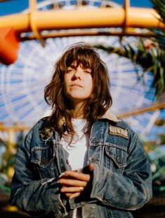 a man standing in front of a ferris wheel with his arms crossed and eyes closed