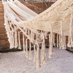 a white hammock hanging from a wooden structure