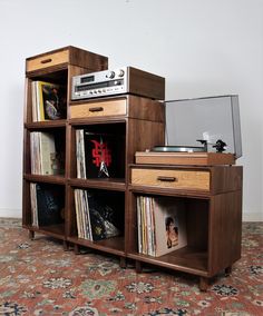 an old record player sits on top of a wooden shelf filled with records and cds