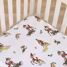 a crib sheet with deers and flowers on it is in the crib