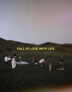 a group of people standing on top of a lush green field next to a rainbow