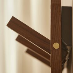 a close up of a clock on a wooden pole with a curtain in the background