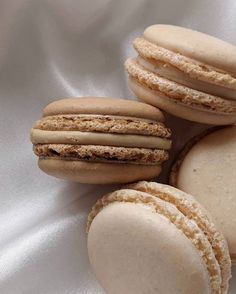 three macaroons are sitting next to each other on a white cloth covered surface